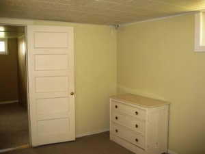 Bedroom featuring baseboards and dark colored carpet