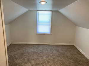 Bonus room featuring carpet flooring and vaulted ceiling