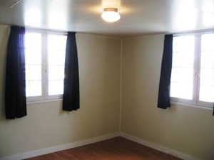 Spare room featuring baseboards and dark wood finished floors