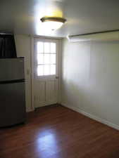 Doorway featuring wood finished floors and baseboards