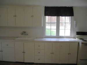 Kitchen with white range with electric cooktop, light countertops, and white cabinetry