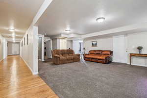 Living area with a textured ceiling and light wood-style floors