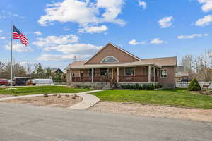 Farmhouse inspired home featuring covered porch and stucco siding