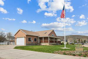 View of front of property with a large porch, stucco siding, concrete driveway, a garage, and a mountain view