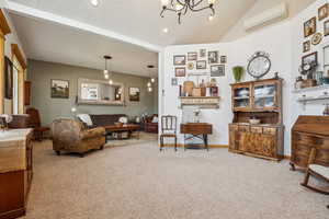 Carpeted living room with a chandelier, a wall mounted AC, lofted ceiling, and recessed lighting