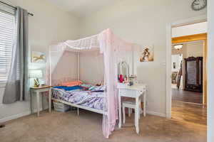 Bedroom featuring light colored carpet and baseboards