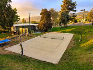 View of community with community basketball court, a lawn, a mountain view, and a patio area