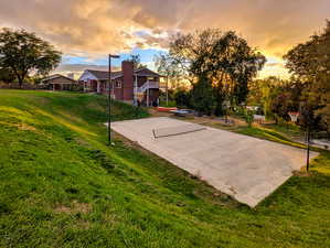 View of basketball court with basketball hoop and a patio