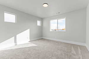Spare room featuring light carpet and baseboards