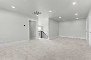Spare room featuring light carpet and recessed lighting