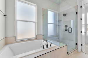 Bathroom featuring a garden tub, a shower stall, and tile patterned floors