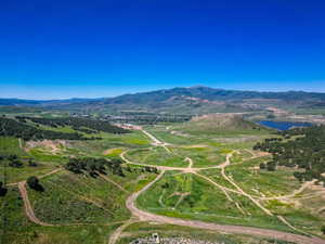 Aerial view of property and surrounding area featuring a mountainous background