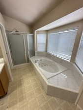 Full bathroom featuring a shower stall, vanity, a tub with jets, and a textured ceiling