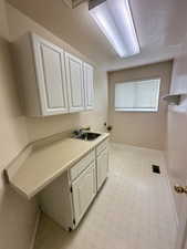 Washroom with cabinet space, hookup for a washing machine, and hookup for an electric dryer