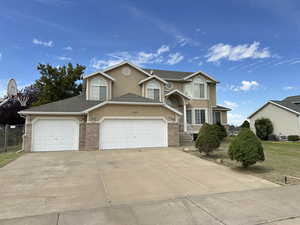 Traditional-style home featuring stucco siding, concrete driveway, a garage, and brick siding