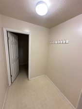 Unfurnished room featuring a textured ceiling and light flooring