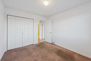 Unfurnished bedroom with carpet flooring and a closet
