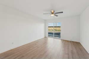 Empty room with light wood-style flooring and ceiling fan