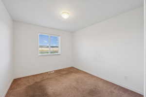 Empty room featuring carpet floors and baseboards