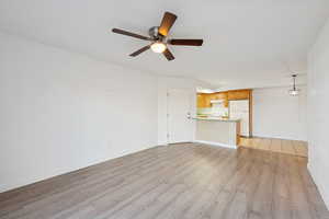 Unfurnished living room featuring light wood-style flooring and ceiling fan