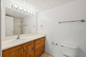 Full bath featuring vanity, light tile patterned floors, and a shower