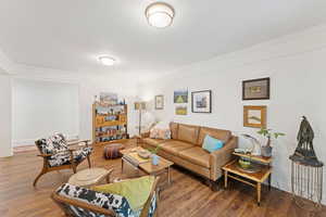 Living area with wood finished floors and crown molding