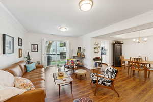 Living area with wood finished floors and ornamental molding