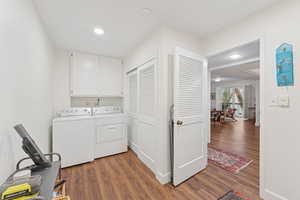 Laundry room featuring dark wood finished floors, cabinet space, washer and dryer, and recessed lighting
