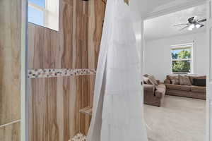 Bathroom/Laundry with plenty of natural light, a shower with shower curtain, and ceiling fan