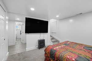 Bedroom with light carpet and recessed lighting