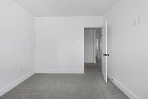 Carpeted empty room with baseboards and a textured ceiling