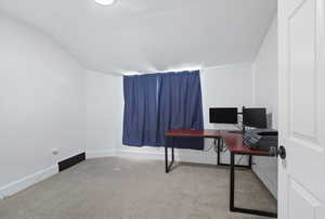 Office area with baseboards and light carpet