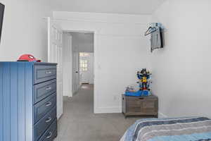 Bedroom featuring light colored carpet and baseboards
