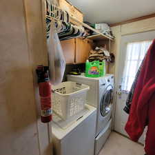 Laundry area with washer and dryer, a textured ceiling, and cabinet space
