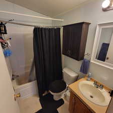 Full bath with a textured ceiling, shower / tub combo, and vanity