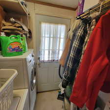 Washroom with independent washer and dryer and light flooring