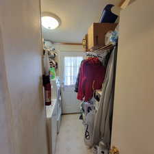 Washroom featuring washing machine and dryer, a textured ceiling, and light flooring