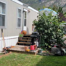 Property entrance featuring a mountain view and a lawn