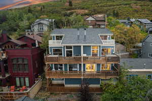 Back of house with a chimney, a shingled roof, and a residential view