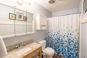 Bathroom with a shower with shower curtain, vanity, and wood finished floors