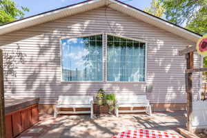 View of property exterior with a patio area and a hot tub