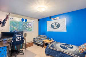 Carpeted bedroom featuring an office area