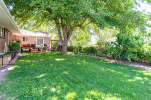 View of green lawn featuring a wooden deck