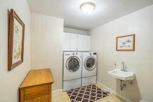 Laundry room with independent washer and dryer and cabinet space