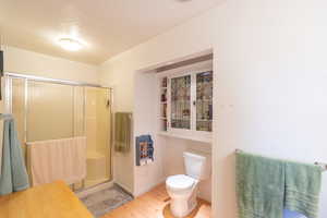 Bathroom with a stall shower and light wood-type flooring