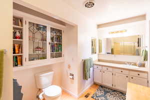 Bathroom with vanity, a stall shower, and light wood-style flooring
