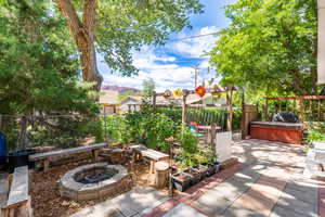 View of patio with a hot tub, a grill, and a fire pit
