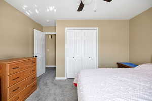 Bedroom with light carpet, a closet, and ceiling fan