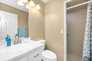 Full bathroom with vanity, a stall shower, and a chandelier