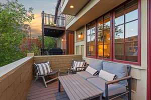 Deck at dusk with a balcony, area for grilling, and outdoor lounge area
